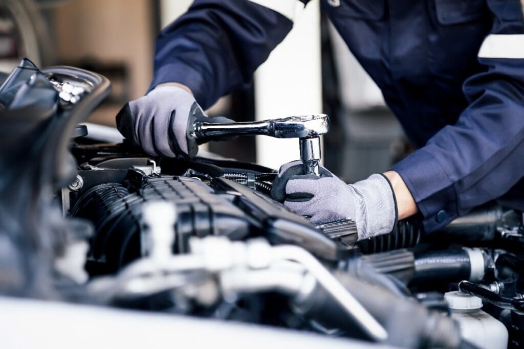 Professioneller Mechaniker bei der Arbeit am Motor des Autos in der Ga